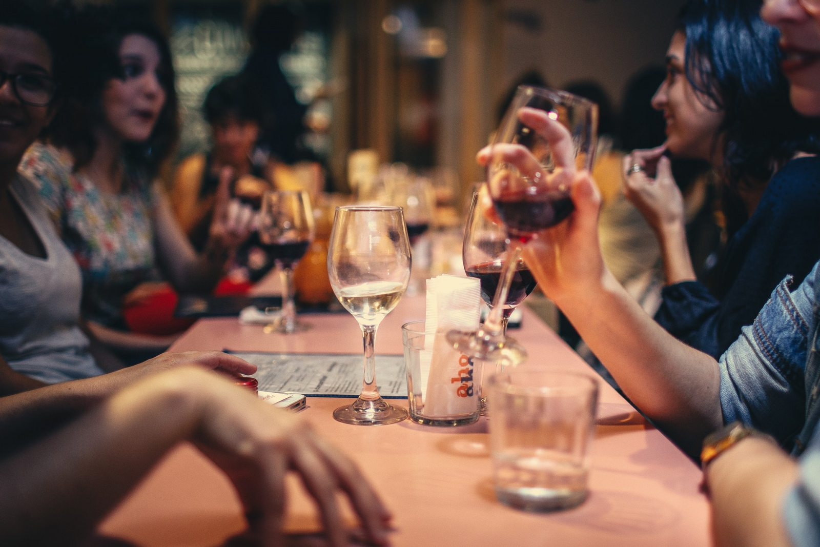 group of people sitting at a table drinking wine